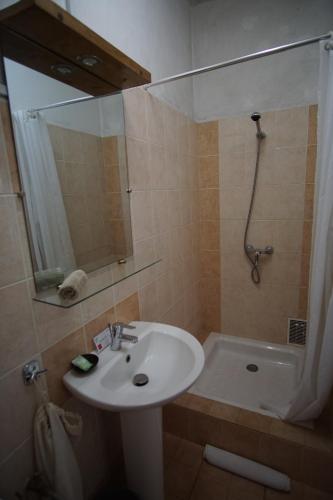 La salle de bains est pourvue d'un lavabo, d'une douche et d'une baignoire. dans l'établissement Lovasoa 4C, à Antsirabe