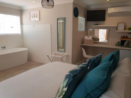 Un dormitorio con una cama, una bañera y un lavabo. en NOOii Open Plan Room, en Pretoria