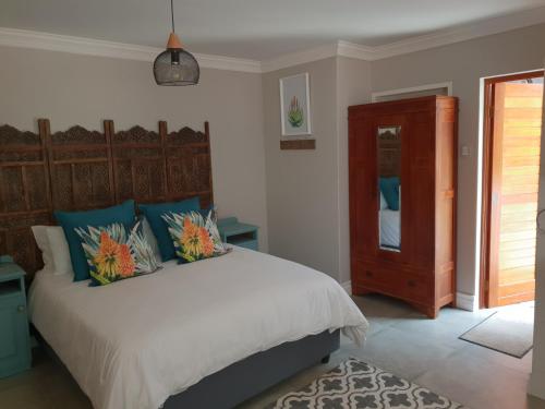 1 dormitorio con 1 cama grande con almohadas azules y naranjas en NOOii Open Plan Room, en Pretoria