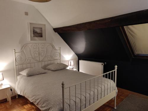 1 dormitorio con cama blanca y pared negra en L'Escape Grill en Silenrieux