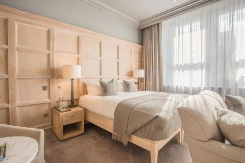 a bedroom with a large bed and a couch at The Scotsman Hotel in Edinburgh