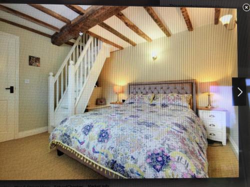 1 dormitorio con 1 cama grande y una escalera en 4 Old Bakery, Bridgnorth, en Bridgnorth