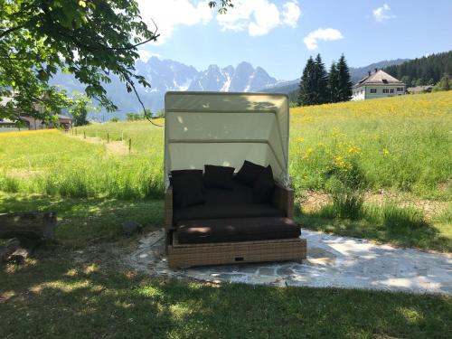 a bed sitting in the grass in a field at Landhaus Koller in Gosau