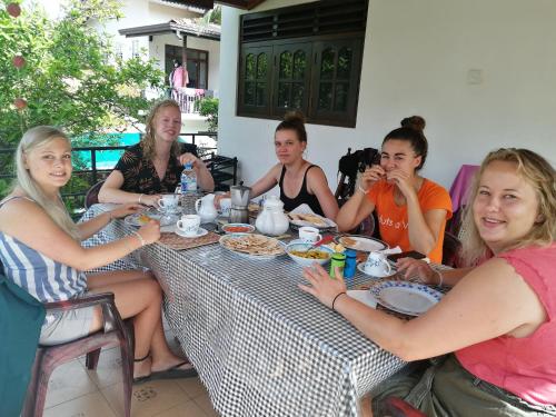 a group of women sitting around a table eating food at Villa Ok in Unawatuna