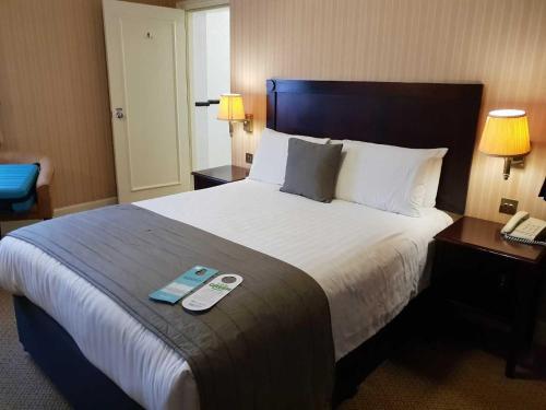 a hotel room with a large bed with a book on it at The Worcester Whitehouse Hotel in Worcester