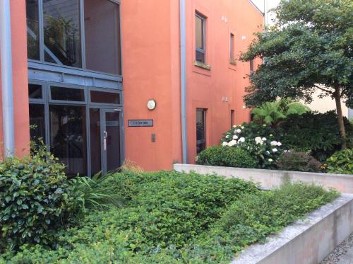 an orange building with a door and some bushes at Chy Bre in Truro