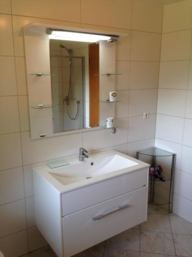 Un baño con un lavabo blanco y un espejo. en Haus Sonnenspitze - Fam. Nessler, en Biberwier