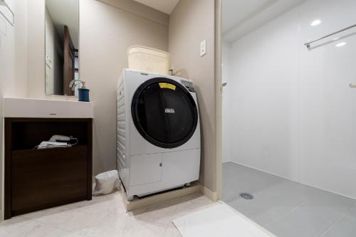 a washer and dryer in a bathroom at Little Santa in Ginowan