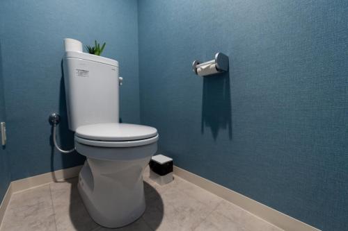 a bathroom with a toilet in a blue wall at Little Santa in Ginowan