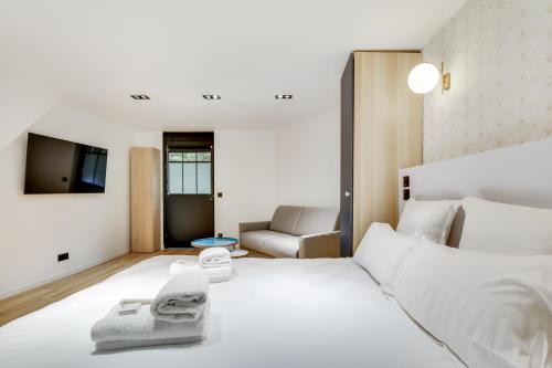 - une chambre avec un lit blanc et un canapé dans l'établissement Pick A Flat's Apartment in Bastille - Rue du Chemin Vert, à Paris