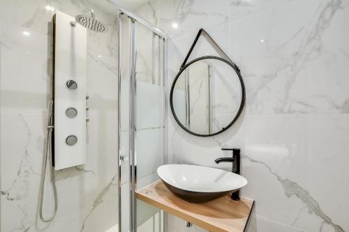 La salle de bains est pourvue d'un lavabo et d'un miroir. dans l'établissement Pick A Flat's Apartment in Bastille - Rue du Chemin Vert, à Paris