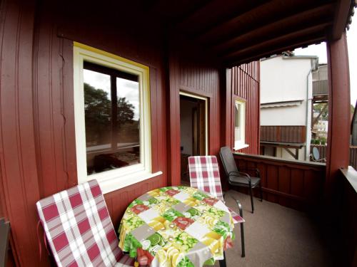 un porche cubierto con mesa y 2 sillas en Apartments Carmen-Braunlage, en Braunlage