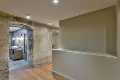 Cette chambre est dotée d'un mur blanc avec un comptoir et un lavabo. dans l'établissement 77 - Urban Sublime Le Marais, à Paris