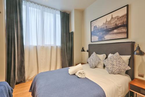 une chambre avec un lit avec une grande fenêtre dans l'établissement 76 - Urban Jardins du Marais, à Paris