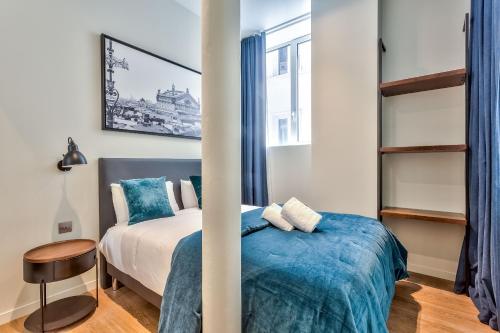 une chambre avec un lit avec une couverture bleue dans l'établissement 77 - Urban Sublime Le Marais, à Paris
