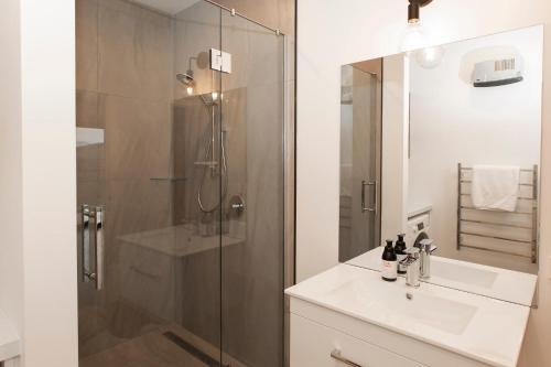 W łazience znajduje się szklana kabina prysznicowa i umywalka. w obiekcie Wahi Nui w mieście Lake Tekapo