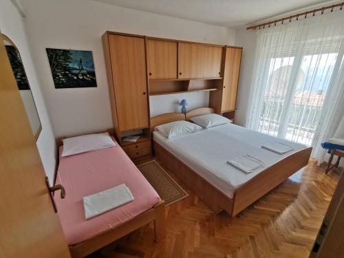 a small bedroom with two beds and a window at Villa Clara apartments Kvarner in Novi Vinodolski