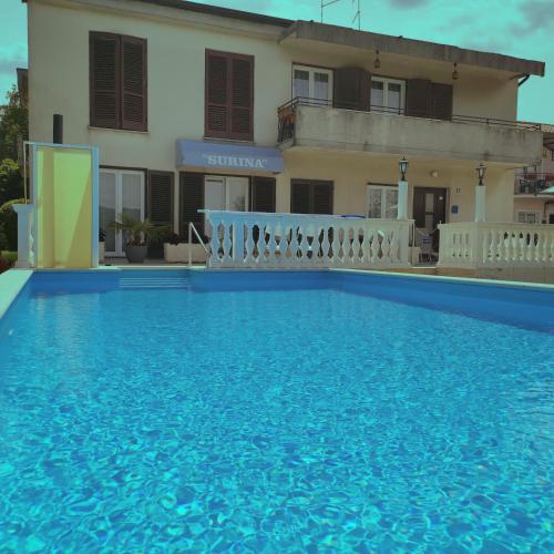a large swimming pool in front of a house at Guest House Surina in Rupa