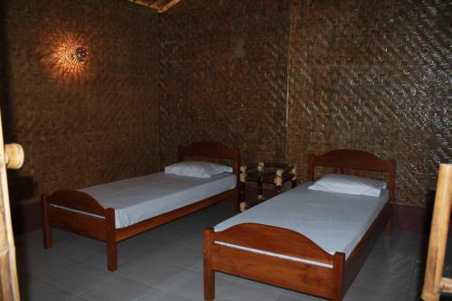 2 camas individuales en una habitación con pared en Bale'ku, en Pangandaran