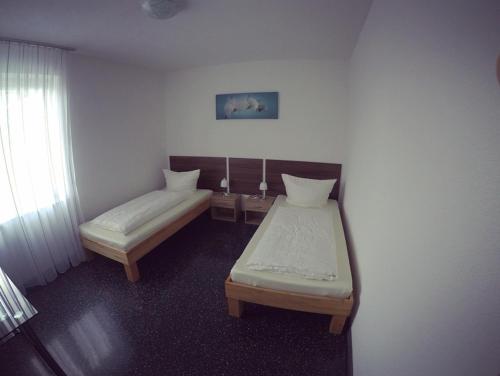 una piccola camera con due letti e una finestra di Gästezimmer Faut a Schorndorf