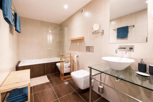 a bathroom with a sink and a toilet and a tub at maresoul - Ferienapartment soul in Raposeira