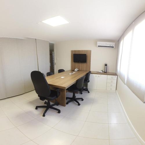 a conference room with a wooden table and chairs at Hotel Pousada do Sol in Aracaju