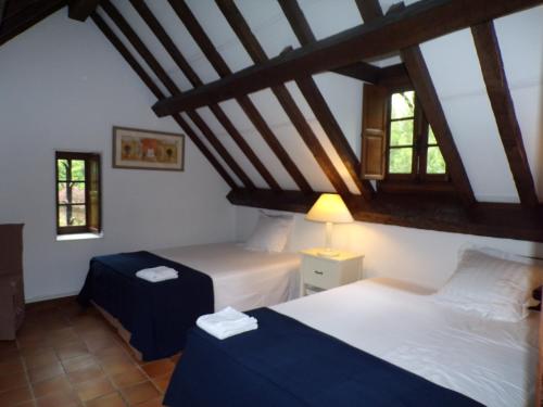 a bedroom with two beds and two windows at Moulin de Bénédicty in Vers