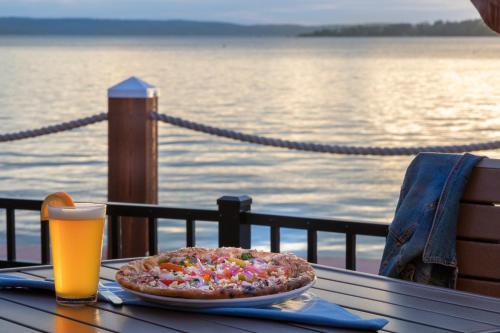 a pizza on a table with a glass of beer at Chautauqua Harbor Hotel - Jamestown in Celoron