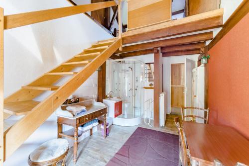 Cette chambre dispose d'un escalier en bois avec une table et un astérisque de table. dans l'établissement Le Sud, à Saint-Priest-sous-Aixe
