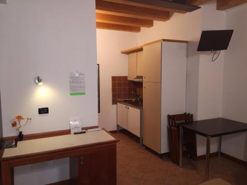 a small kitchen with a table and a refrigerator at Ca' Del Sasso in Verona
