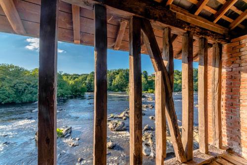 a view from the inside of a building overlooking a river at Le Sud in Saint-Priest-sous-Aixe