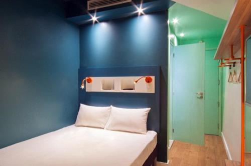 ibis budget Divinopolis في ديفينوبوليس: غرفة زرقاء مع سرير بجدار ازرق