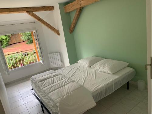 a bed in a bedroom with a window at La grange de mémé Yvette in Vaulnaveys-le-Haut