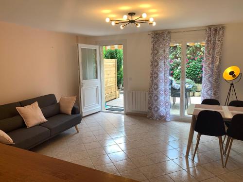 un salon avec un canapé et une table dans l'établissement La grange de mémé Yvette, à Vaulnaveys-le-Haut