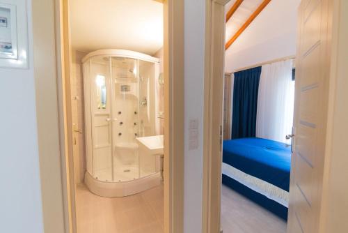 a bathroom with a shower and a bed in a room at All Saints Villas in Plataria