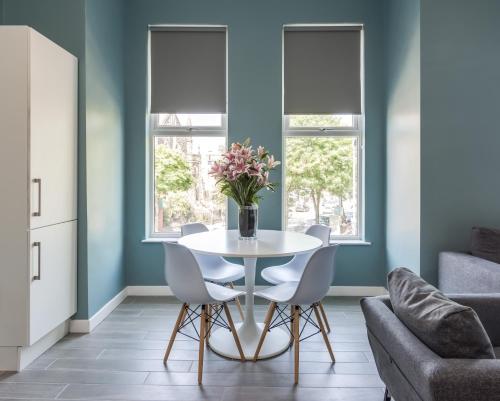a dining room with a white table and chairs at Wellington Park Boutique Apartments in Belfast