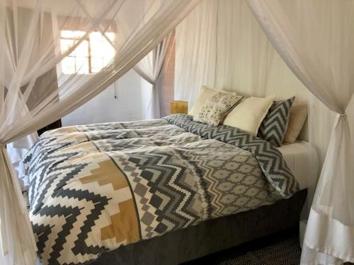 a bedroom with a bed with a canopy at Villa Leopards Lookout in Marloth Park
