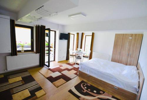 a bedroom with a bed and a table in it at Nature House Predeal in Predeal