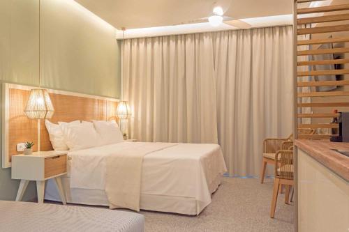 um quarto de hotel com uma cama, uma mesa e cadeiras em Eco Green Residences & Suites em Torone