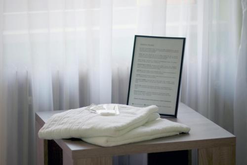 a pile of towels sitting on a table with a sign at Penzion Nový mlýn in Staré Splavy