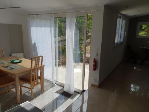 d'une salle à manger avec une table et une porte coulissante en verre. dans l'établissement Le verger d'Honfleur, à Honfleur