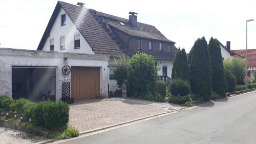 ein weißes Haus mit Garage auf einer Straße in der Unterkunft Ferienwohnung Dippold in der fränkischen Schweiz in Heiligenstadt