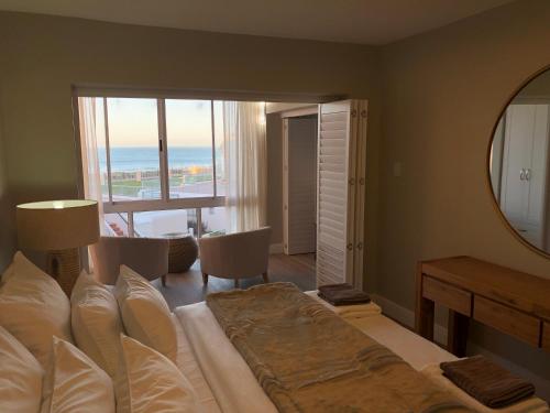 a bedroom with a large bed with a view of the ocean at Summerseas 56 in Port Elizabeth