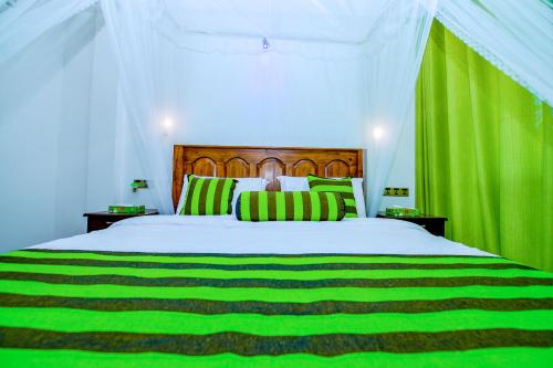 a bedroom with a large bed with green curtains at Third Eye Ella in Ella