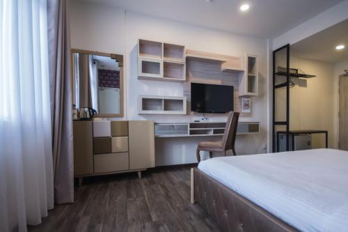 a bedroom with a bed and a desk and a tv at Wifi Boutique Hotel in George Town