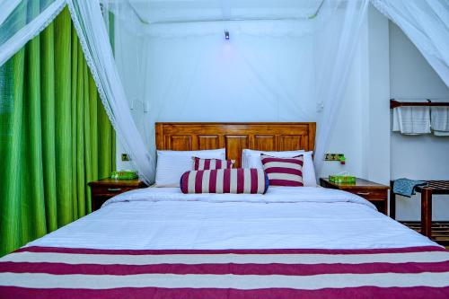 a bedroom with a large bed with red and white pillows at Third Eye Ella in Ella