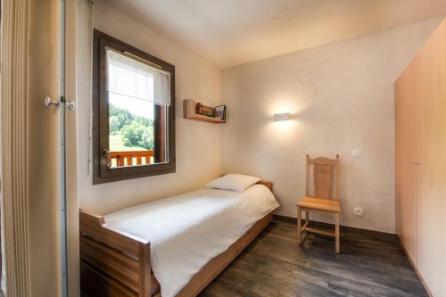 Neige et Soleil في مونتشافين: غرفة نوم صغيرة بها سرير ونافذة