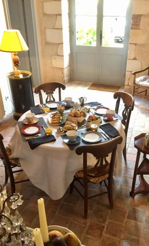 a table with food on it in a room at Chambres d'hôtes La Borderie du Gô près de La Rochelle - Nieul in Nieul-sur-Mer