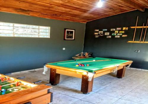 a ping pong table in a room with a pool at Casa de Temporada em Capitólio (Paz e Tranquilidade) in Capitólio