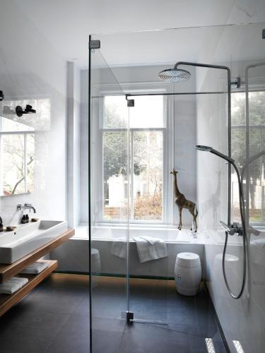 a bathroom with a shower with a giraffe in the window at City B&B Villa Nicola in Amsterdam